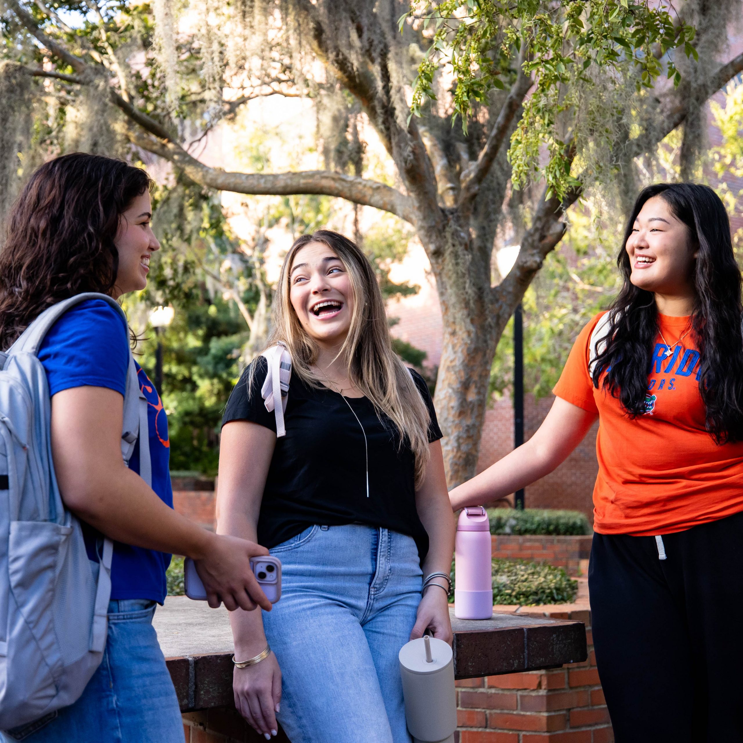 Three students talking to each other in Turlington Plaza.