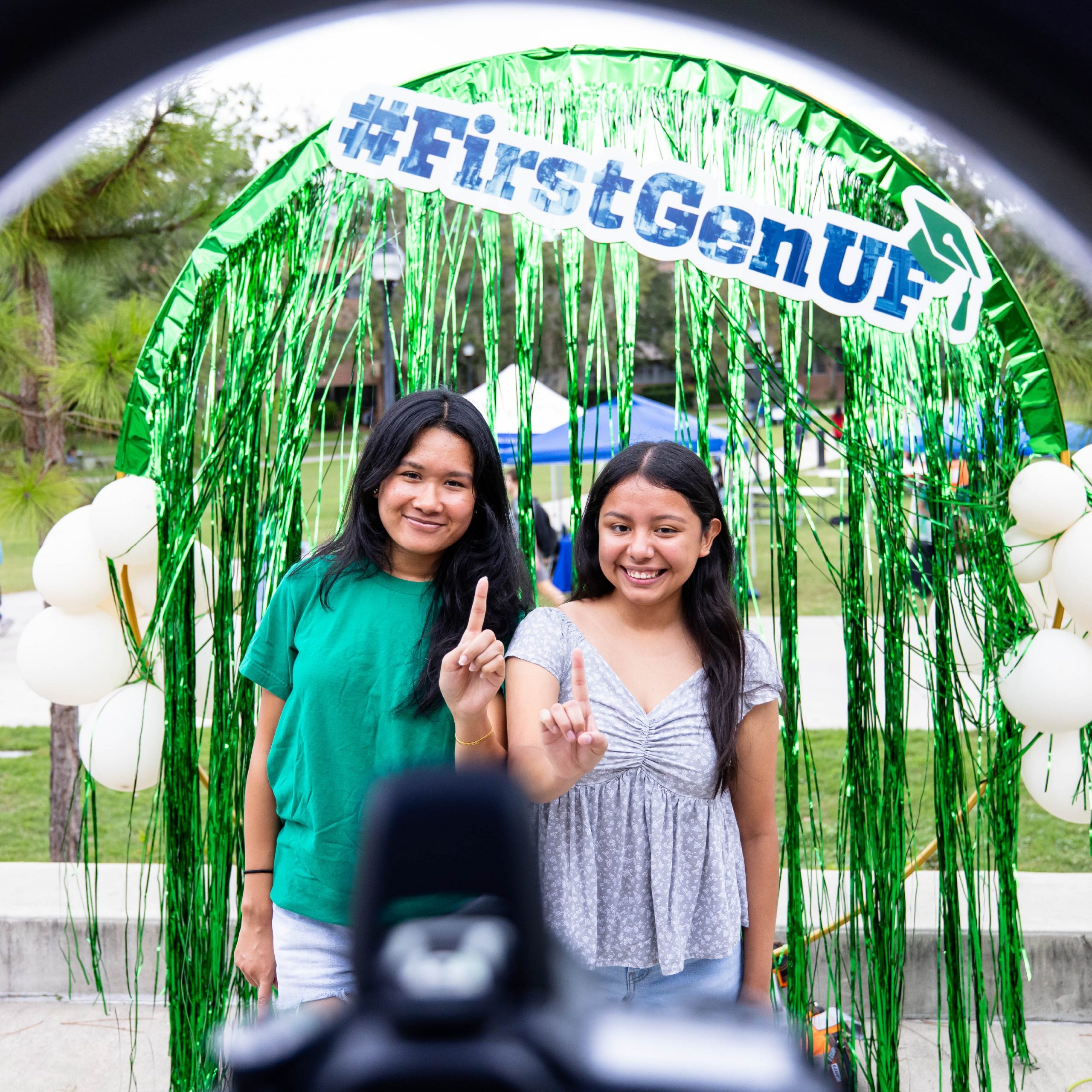 Two students pose for a photo making a #1 hand sign.